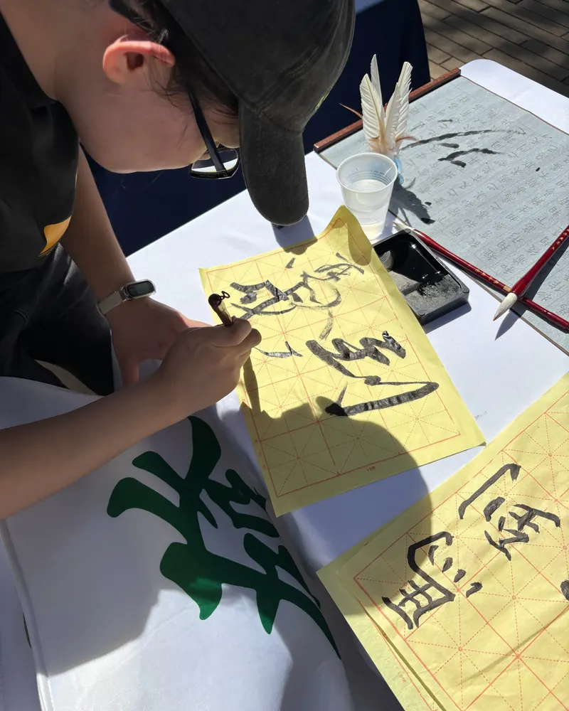 A member brushing calligraphy at the club’s outdoor table
